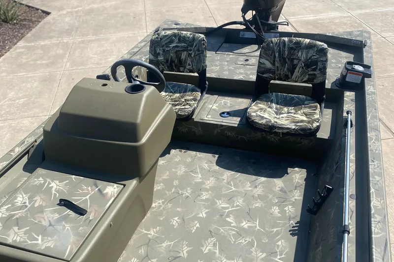 Slide: The Image of 2024 Tracker Grizzly 1754SC boat with camouflage seats and steering console. - 6