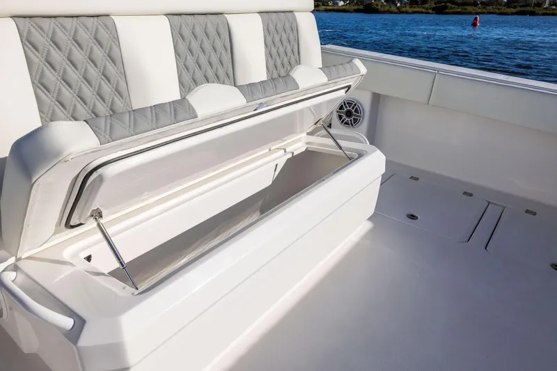 Slide: The Image of 2025 Invincible 38 Catamaran with open storage compartment on deck, near water. - 12