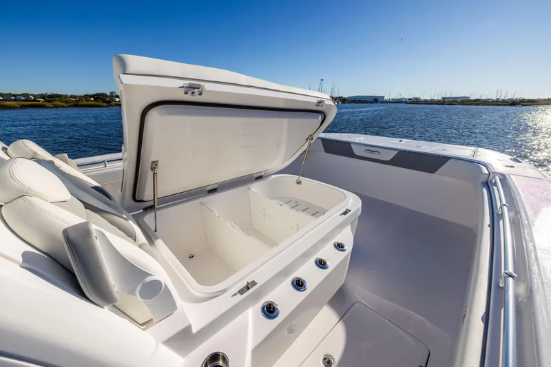 Slide: The Image of 2025 Invincible 38 Catamaran with open storage compartment, docked on a sunny day. - 14