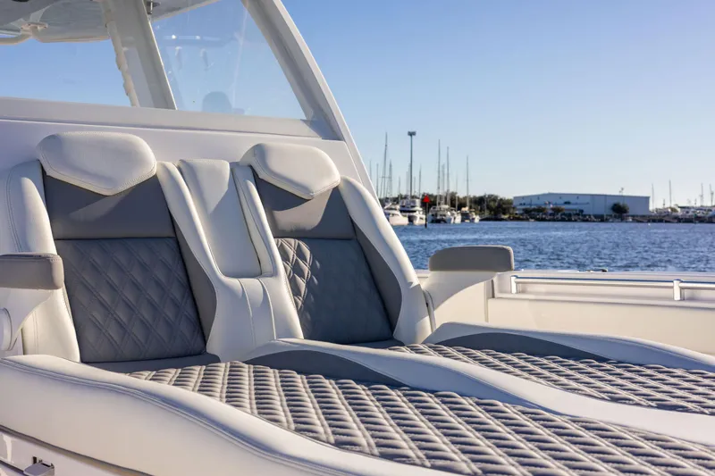 Slide: The Image of Luxurious seating on 2025 Invincible 38 Catamaran, with marina in the background. - 16