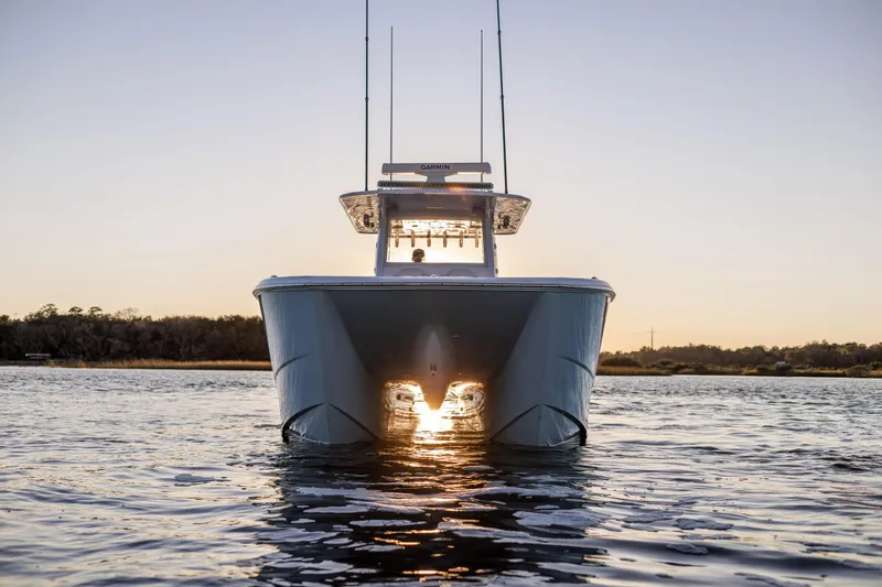 Slide: The Image of 2025 Invincible 38 Catamaran on water at sunset, front view. - 2