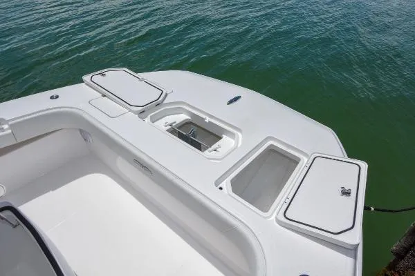 Slide: The Image of 2025 Invincible 38 Catamaran deck with storage compartments and livewell, on calm water. - 22