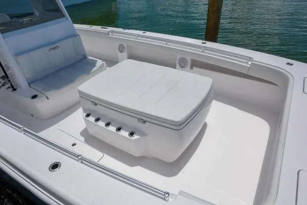 Slide: The Image of 2025 Invincible 38 Catamaran interior with seating and storage, docked by the water. - 27