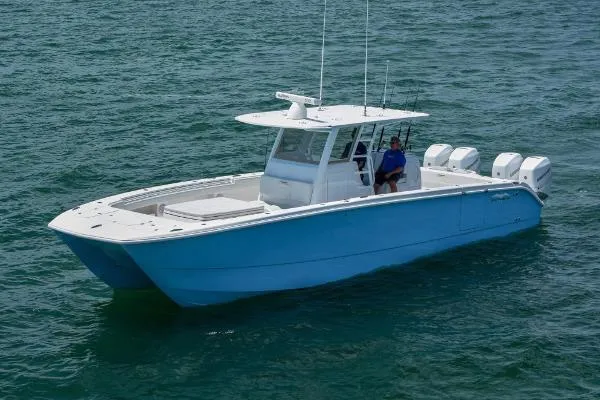 Slide: The Image of 2025 Invincible 38 Catamaran on water, featuring sleek design and multiple outboard engines. - 28