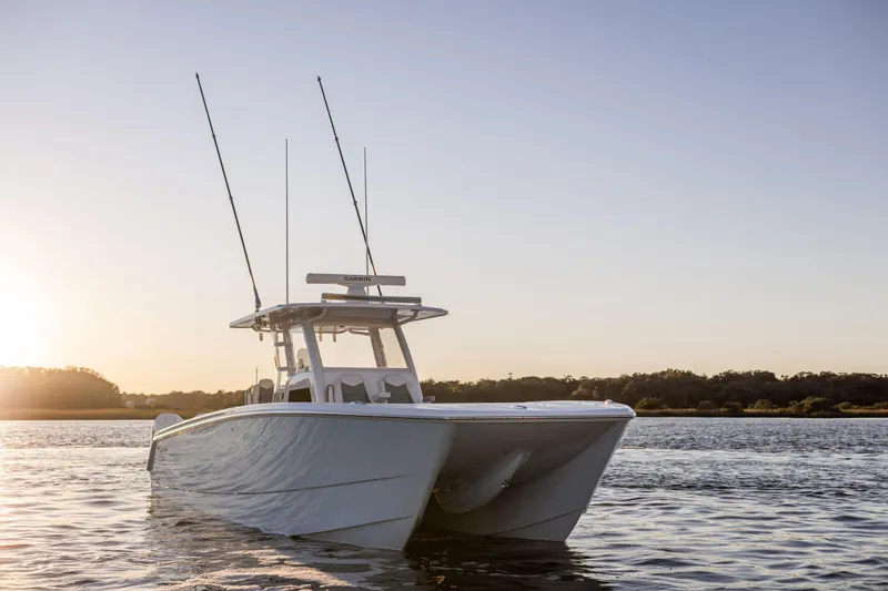 Slide: The Image of 2025 Invincible 38 Catamaran on calm water at sunset. - 3