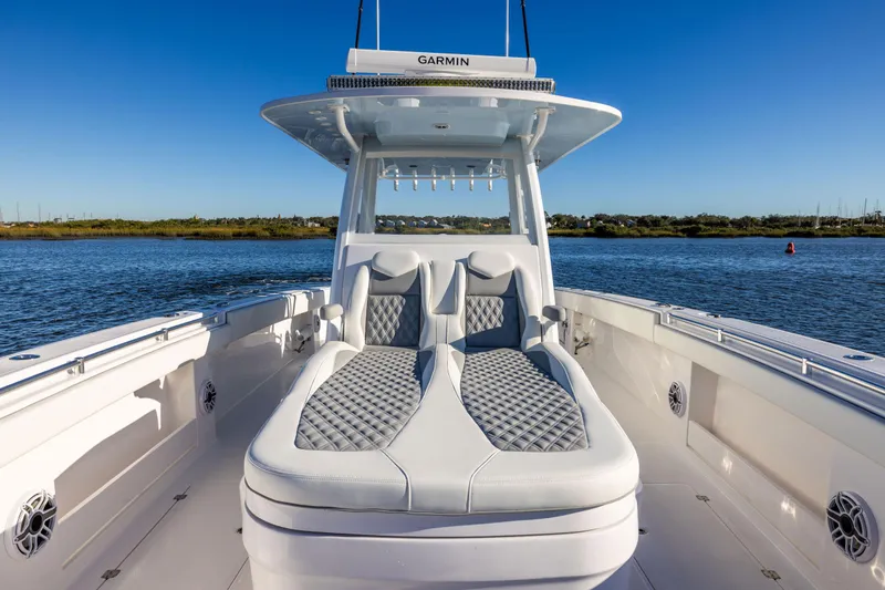 Slide: The Image of 2025 Invincible 38 Catamaran with sleek seating, cruising on a calm waterway. - 15