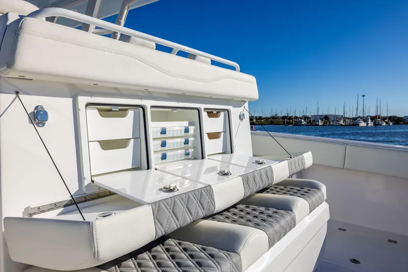 Slide: The Image of 2025 Invincible 38 Catamaran with luxurious seating and storage, docked in a marina under clear skies. - 11