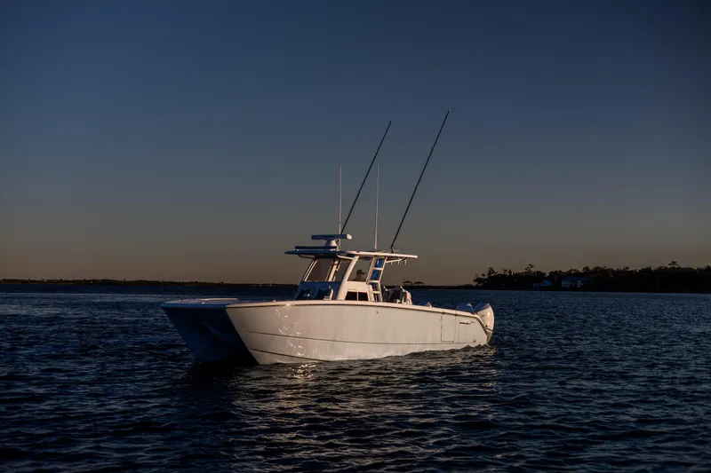 Slide: The Image of 2025 Invincible 38 Catamaran on calm water at sunset. - 7