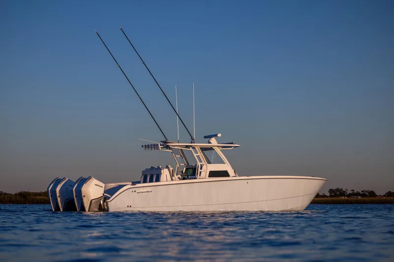 Slide: The Image of 2025 Invincible 38 Catamaran on calm water at sunset. - 4