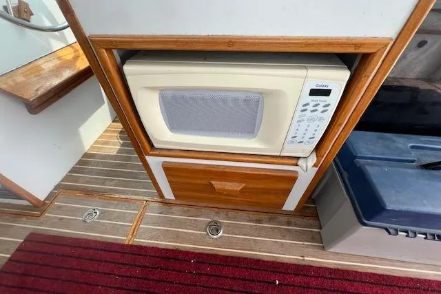 Slide: The Image of 2007 Northern Bay Hardtop Cruiser interior with microwave and wooden cabinetry. - 13