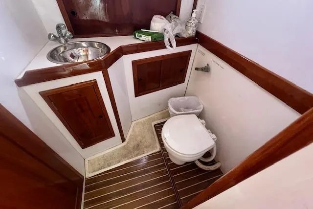 Slide: The Image of 2007 Northern Bay Hardtop Cruiser bathroom with wooden cabinetry and compact toilet. - 14