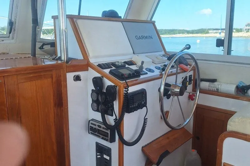 Slide: The Image of 2007 Northern Bay Hardtop Cruiser helm with Garmin navigation, wooden accents, and ocean view. - 3
