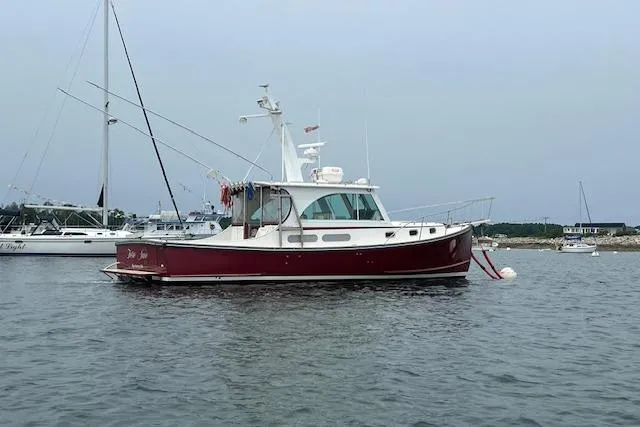 Slide: The Image of 2007 Northern Bay Hardtop Cruiser/Fishing Vessel on calm water, red hull, anchored near shore. - 33