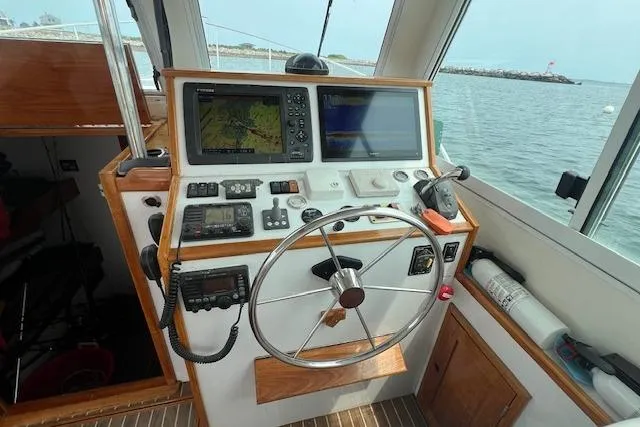 Slide: The Image of 2007 Northern Bay Hardtop Cruiser helm with navigation equipment and steering wheel. - 4