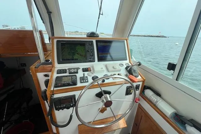 Slide: The Image of 2007 Northern Bay Hardtop Cruiser helm with navigation equipment, steering wheel, and ocean view. - 6