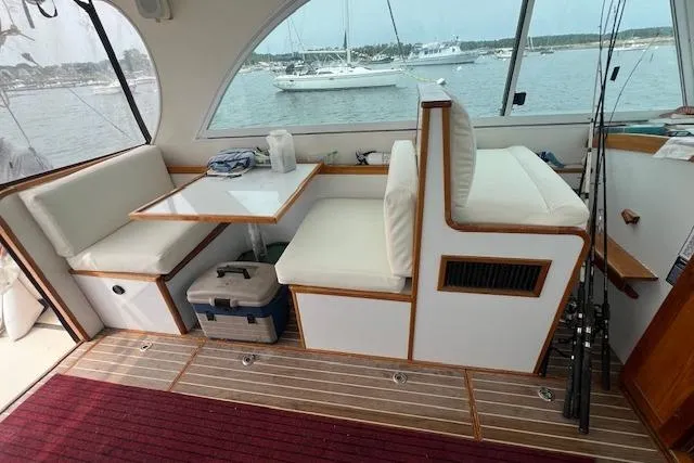 Slide: The Image of Interior of 2007 Northern Bay Hardtop Cruiser with seating, table, and fishing rods. - 8