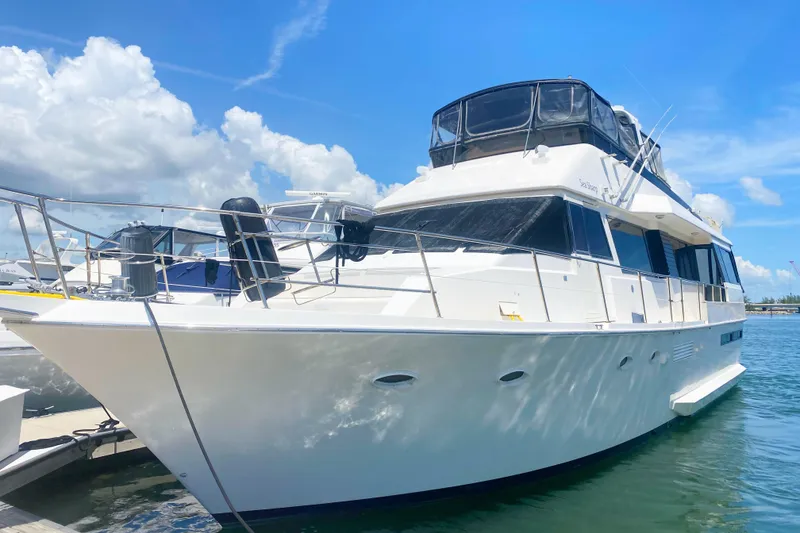 The Image of 1990 Viking 63 Motor Yacht docked under a clear blue sky. - 1