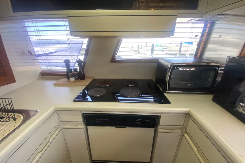 Slide: The Image of 1990 Viking 63 Motor Yacht kitchen with stove, oven, and countertop appliances. - 24