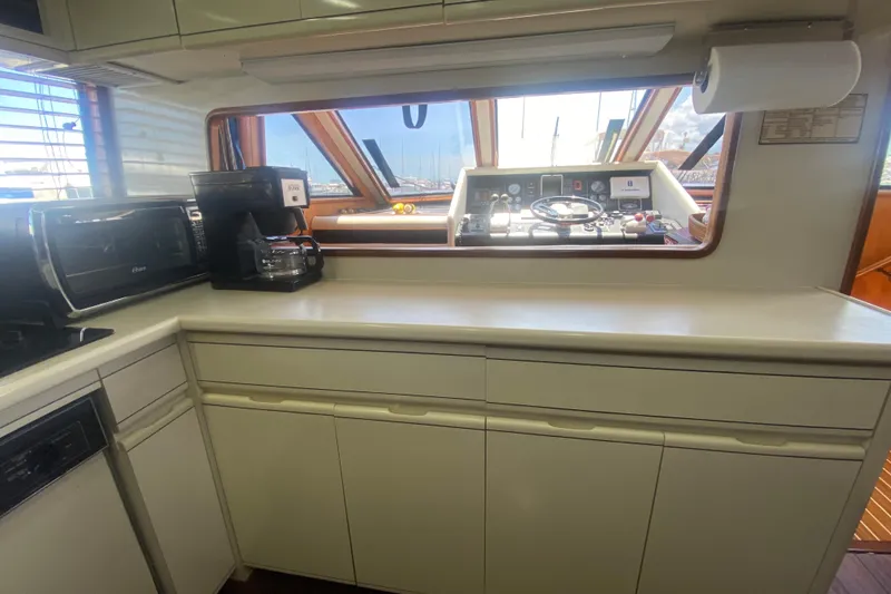 Slide: The Image of Interior of 1990 Viking 63 Motor Yacht kitchen with appliances and helm view. - 25
