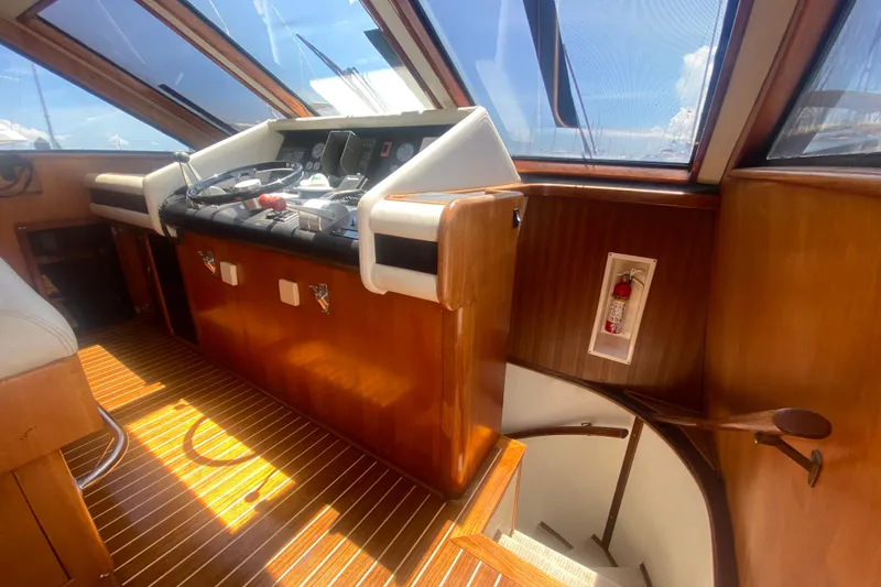 Slide: The Image of Interior helm of 1990 Viking 63 Motor Yacht with wooden finish and steering controls. - 29