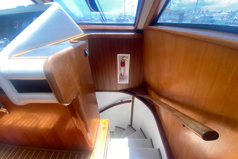 Slide: The Image of Interior of 1990 Viking 63 Motor Yacht with wooden stairs and fire extinguisher. - 32