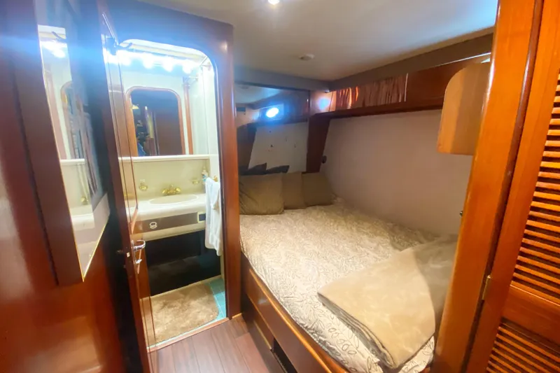 Slide: The Image of Cozy bedroom and bathroom in 1990 Viking 63 Motor Yacht, featuring wood accents and soft lighting. - 36
