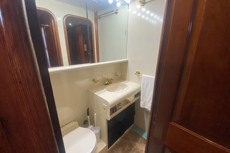 Slide: The Image of Luxurious bathroom in a 1990 Viking 63 Motor Yacht with elegant wood accents. - 38