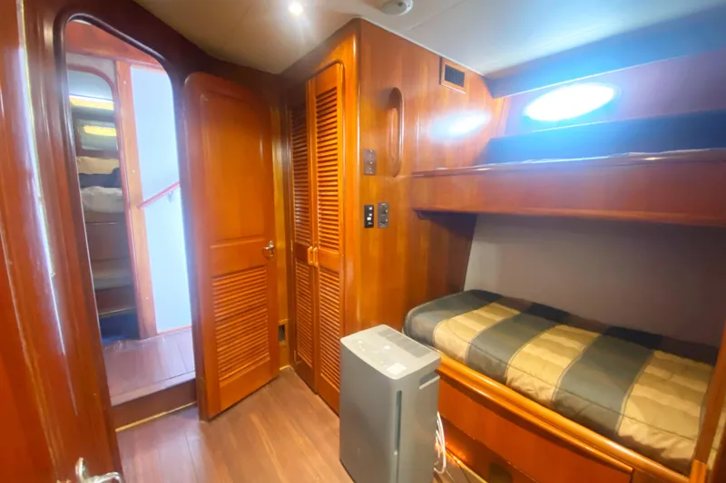 Slide: The Image of Interior of 1990 Viking 63 Motor Yacht with wooden bunk beds and storage. - 41