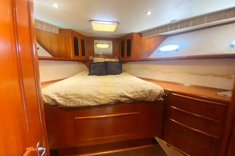 Slide: The Image of Cozy bedroom in 1990 Viking 63 Motor Yacht with wood paneling and built-in storage. - 42