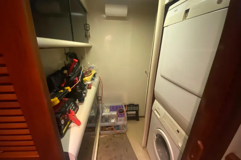 Slide: The Image of Laundry room with stacked washer and dryer on a 1990 Viking 63 Motor Yacht. - 48