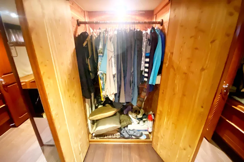 Slide: The Image of Wooden closet with clothes and shoes inside a 1990 Viking 63 Motor Yacht. - 54