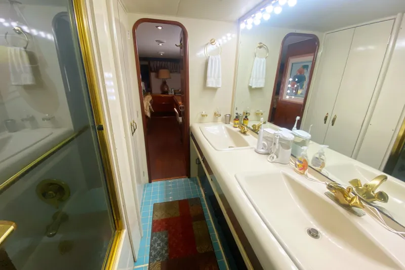 Slide: The Image of Luxurious bathroom in 1990 Viking 63 Motor Yacht with double sinks and gold fixtures. - 56