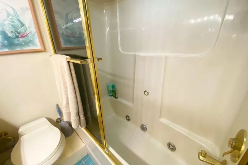 Slide: The Image of Bathroom in 1990 Viking 63 Motor Yacht with shower, toilet, and gold accents. - 57