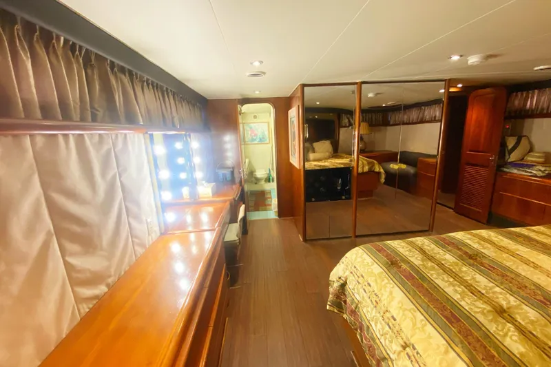 Slide: The Image of Luxurious interior of 1990 Viking 63 Motor Yacht with elegant wood finishes and mirrored closet. - 58