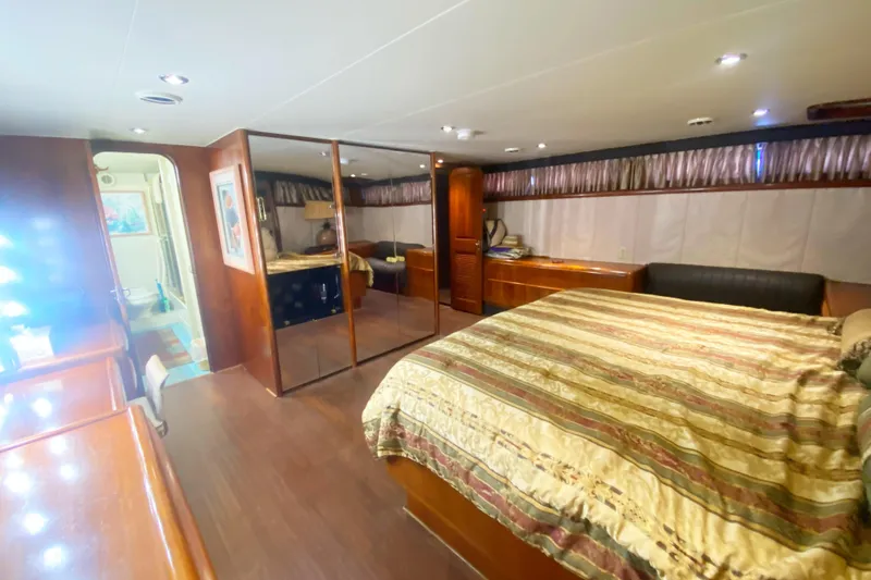 Slide: The Image of Luxurious bedroom interior of a 1990 Viking 63 Motor Yacht with elegant wood finishes. - 59