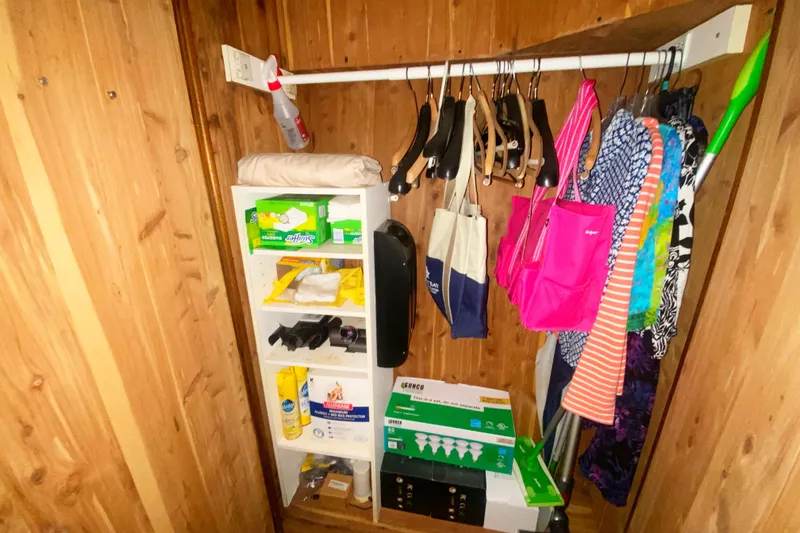 Slide: The Image of Wooden closet on 1990 Viking 63 Motor Yacht with shelves and hanging clothes. - 62