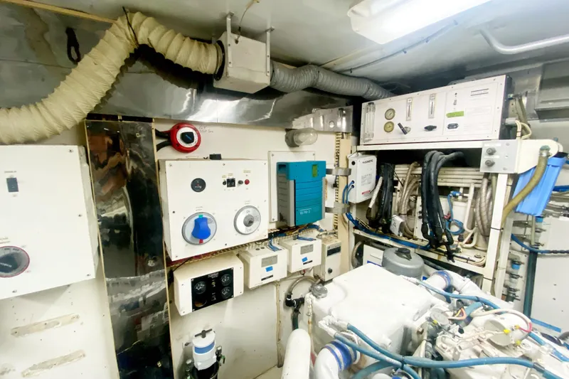 Slide: The Image of Engine room of a 1990 Viking 63 Motor Yacht with control panels and machinery. - 68