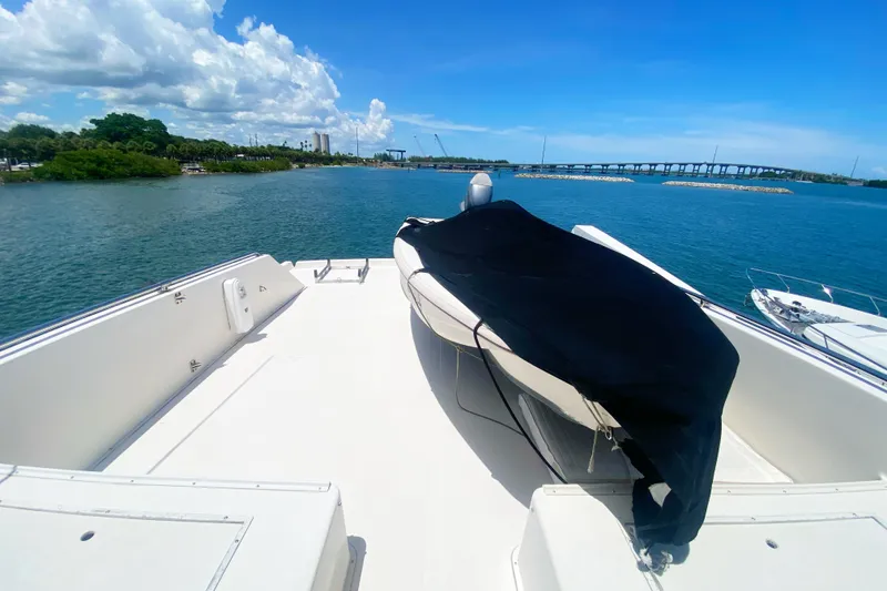 Slide: The Image of 1990 Viking 63 Motor Yacht deck with covered equipment, overlooking serene water and distant bridge. - 71