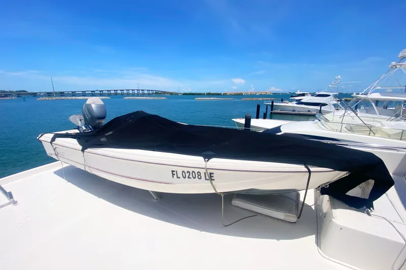 Slide: The Image of 1990 Viking 63 Motor Yacht with covered boat on deck, docked by a scenic waterfront. - 72