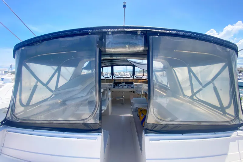 Slide: The Image of 1990 Viking 63 Motor Yacht cockpit with clear enclosure, sunny marina view. - 74