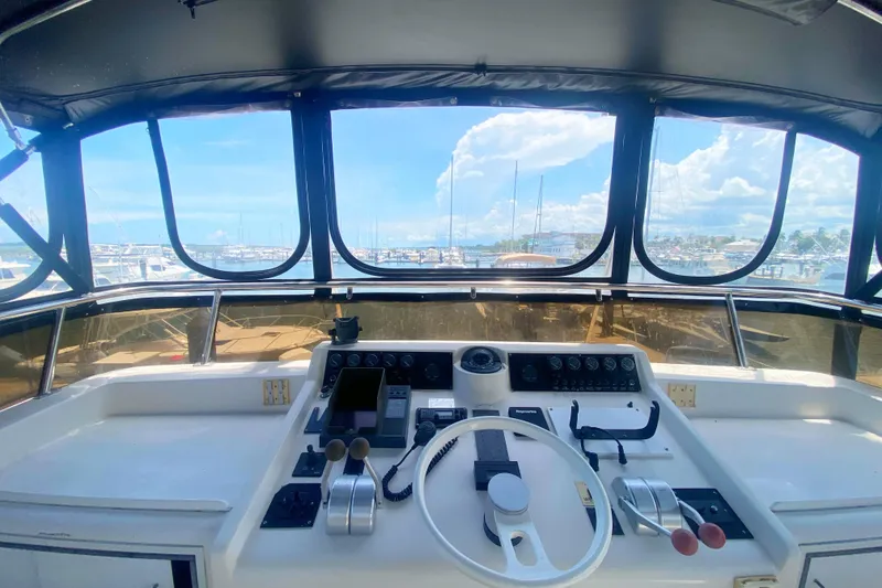 Slide: The Image of Cockpit view of 1990 Viking 63 Motor Yacht with marina in background. - 76