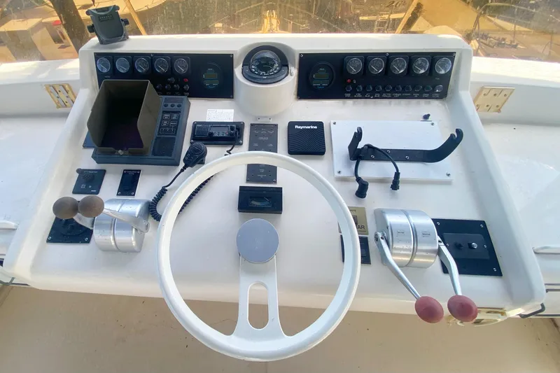 Slide: The Image of Control panel of a 1990 Viking 63 Motor Yacht with steering wheel and navigation instruments. - 77