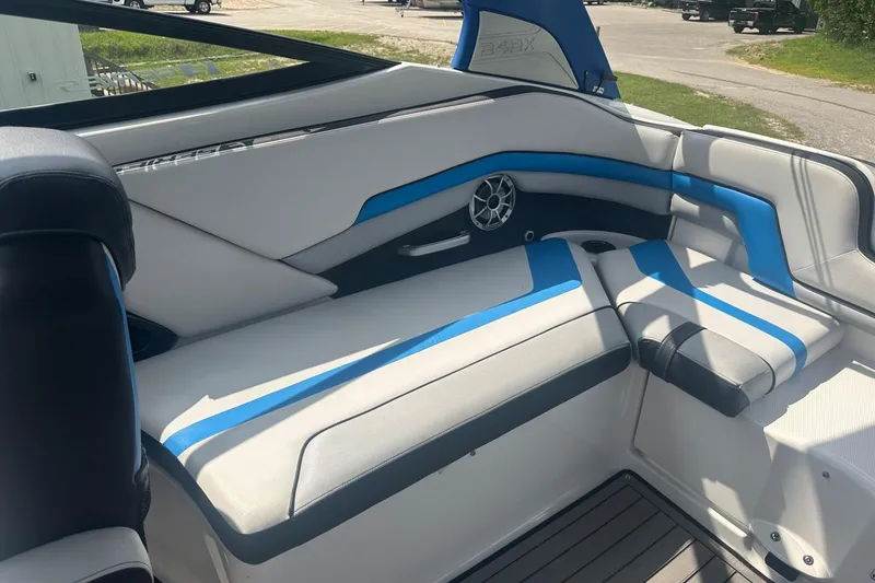 Slide: The Image of 2018 Yamaha 242 X boat interior with blue and white seating, featuring a speaker. - 16
