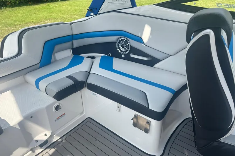 Slide: The Image of 2018 Yamaha 242 X boat interior with blue and gray seating, speaker, and sleek design. - 17