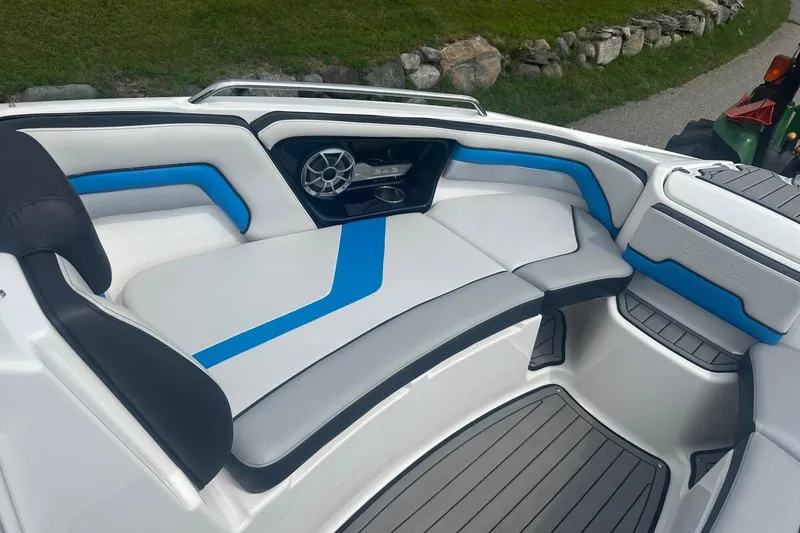 Slide: The Image of 2018 Yamaha 242 X boat interior with blue and gray seating, speaker, and sleek design. - 22
