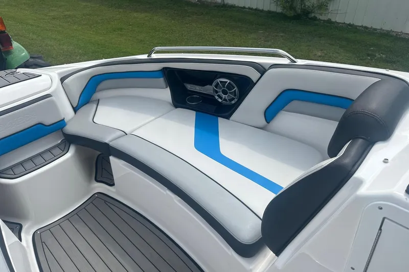 Slide: The Image of 2018 Yamaha 242 X boat interior with blue and white seating, featuring a speaker. - 23