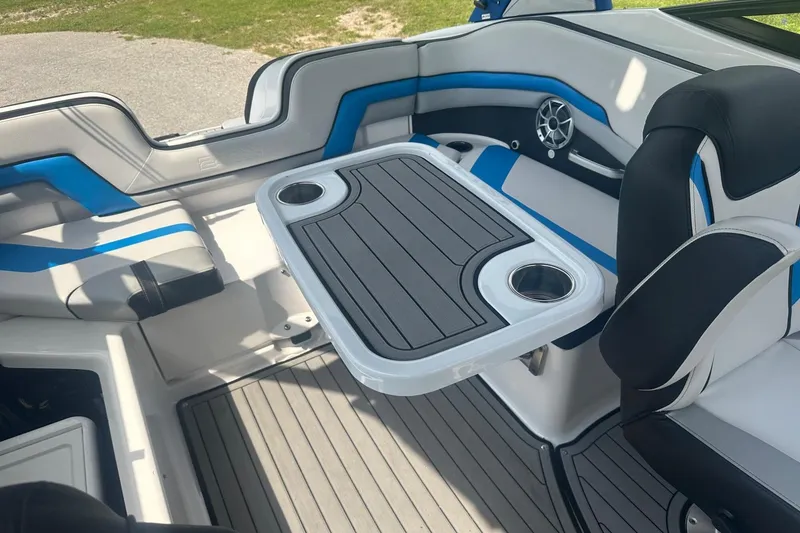 Slide: The Image of 2018 Yamaha 242 X boat interior with seating and table, featuring blue and gray accents. - 29