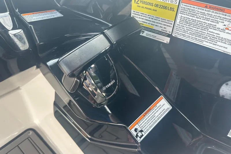 Slide: The Image of Close-up of 2018 Yamaha 242 X boat controls with safety labels. - 36