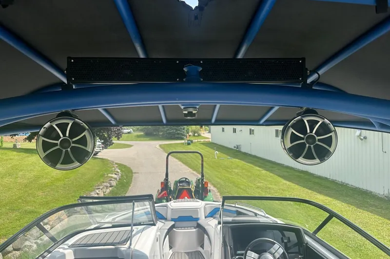 Slide: The Image of 2018 Yamaha 242 X boat interior with speakers and steering wheel, parked on a driveway. - 39