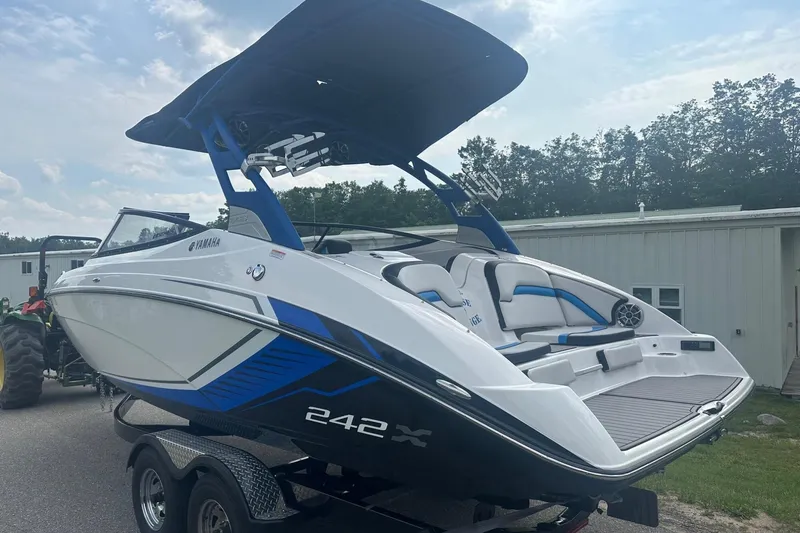 Slide: The Image of 2018 Yamaha 242 X boat with sleek design and blue accents on a trailer. - 4